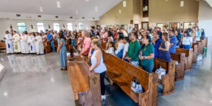 Congregation standing in prayer during Mass at Our Lady of the Rosary Catholic Church.